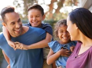 A smiling family with their new home, illustrating the successful application of Stallion Moving & Storage's moving tips. The scene captures strategic planning with labeled boxes, minimalistic decluttering, and a sense of calm and organization, reflecting a smooth and stress-free moving process guided by professional expertise.